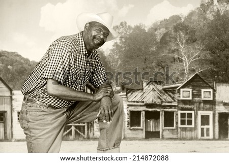A tall, senior black cowboy in an old western town.  Sepia Toned