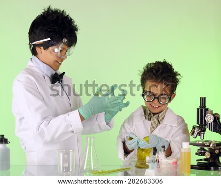 A preteen having fun with his preschool brother in a chemistry lab, both working as \