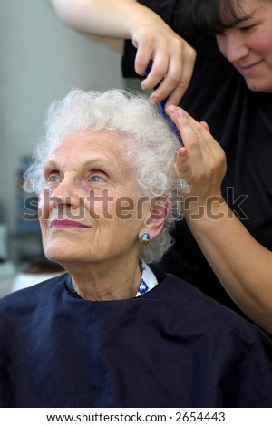 Attractivr senior getting her hair styled at a beauty salon.