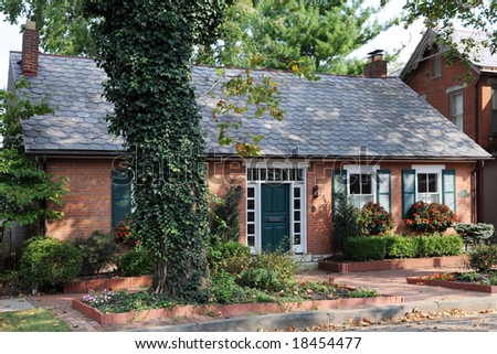 An small, well maintained urban brick home in early fall.