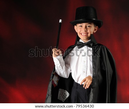 A happy elementary boy performing as a magician.  Horizontal composition with space for your text.