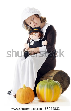 An elementary-aged Pilgrim girl nodding off against the doll on her lap.  Two pumpkins in the foreground.  On a white background.
