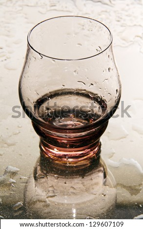 empty transparent glass with a wet mirror with water drops.