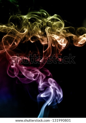 jet and tendrils of smoke painted in different colors, the photo on a dark background.