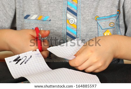 baby scissors cuts paper, close-up of child hands.
