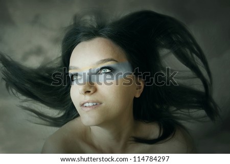 Beautiful fantasy expressive portrait of a girl with long hair in the wind and extravagant makeup in the cloudy sky background