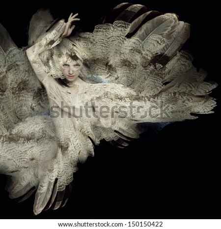 Beautiful artistic portrait of a girl with plumage on black background