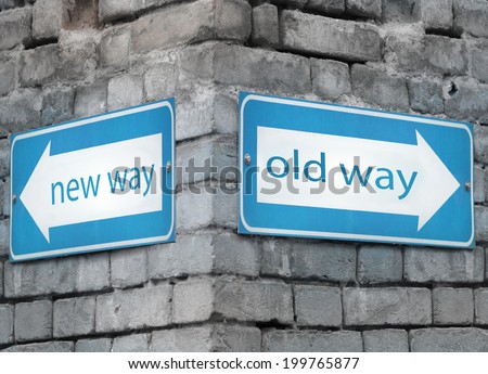 Two blue light directions arrow at the angle on a grey old brick wall with the text new and old way