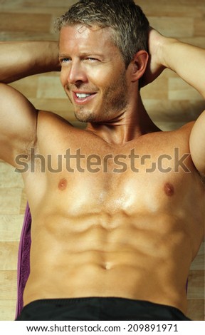 Sexy man fitness model while doing abdominal exercises