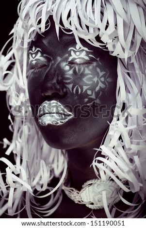 creative make up like Ethiopian mask, white pattern on black face close up