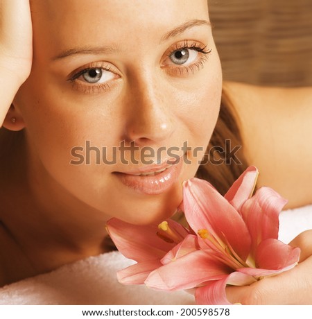 beauty young woman with flower close up getting spa