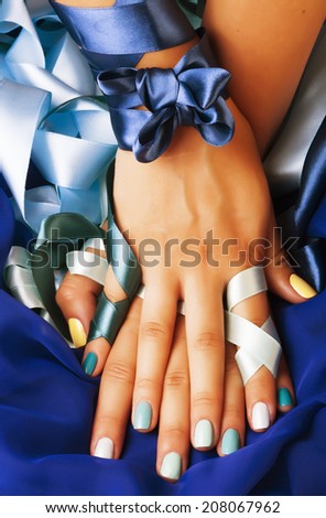 blue manicure with ribbon close up as a gift
