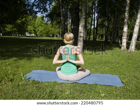 blonde girl doing yoga in green park
