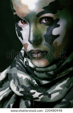 Beautiful young fashion woman with military style clothing and face paint make-up, khaki colors