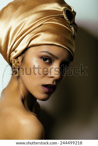 beauty african woman in shawl on head, very elegant look with gold jewelry close up