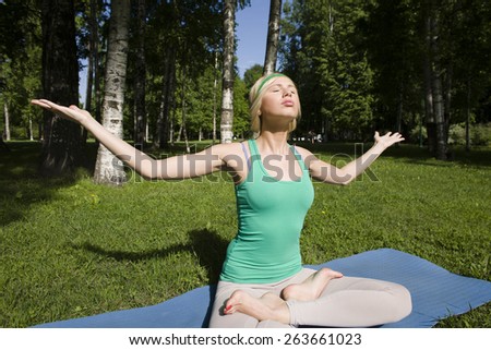blonde real girl doing yoga in green park on grass, gym treining
