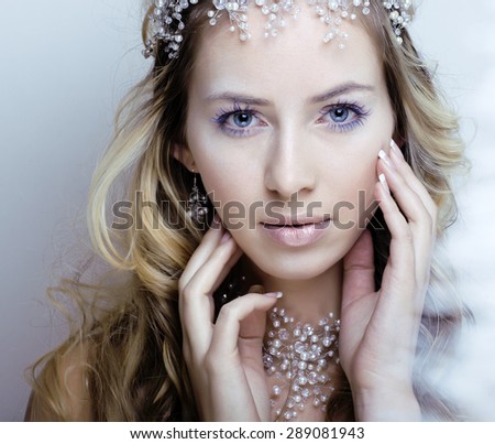 beauty young snow queen in fairy flashes with hair crown on her head close up