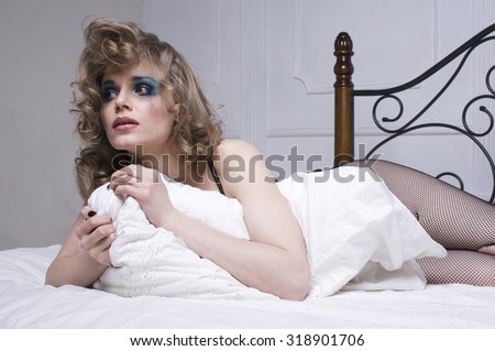 crying woman laying in bed depressed, real blond close up