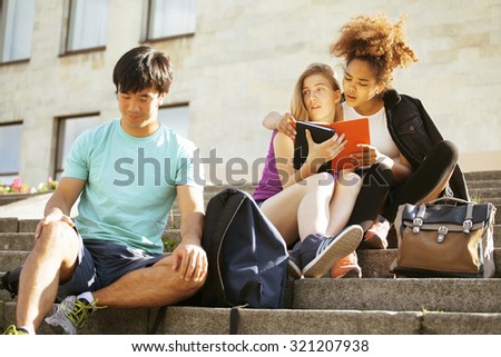 cute group of teenages at the building of university with books huggings, smiling, back to school