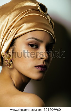 beauty african woman in shawl on head, very elegant look with gold jewelry close up mulatto