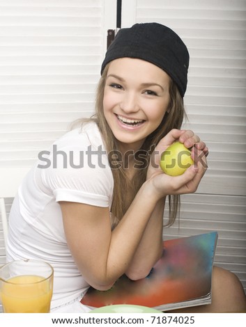 portrait of happy funny teenage girl having breakfast and reading journal