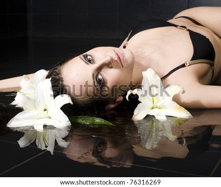 portrait of pretty young lady with lily in water around her