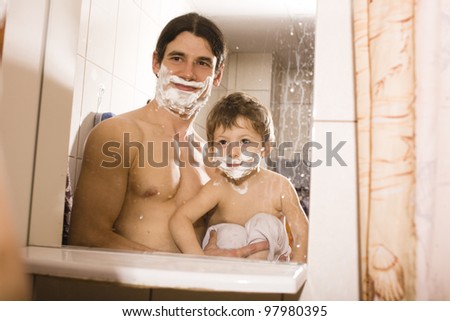 Portrait of son and father enjoying while shaving together
