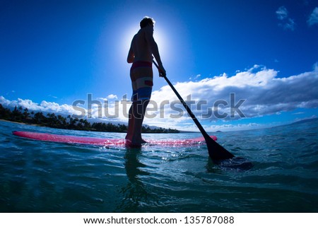 Stand up paddle boarder exercising in the ocean