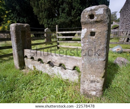 Ancient village stocks located in the church yard of Airton village, Yorkshire