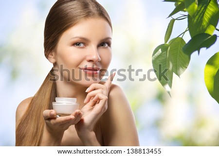beautiful young women advertising  a herbal cosmetics cream on natural blurred background