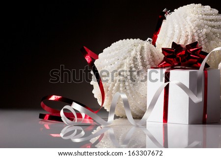 christmas white  ball and gift red box with bow on dark grey background