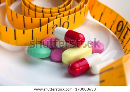 close-up colorful meal and pills on white plate