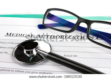 close-up optical glasses,  stethoscope and medical authorization form on green board on white background