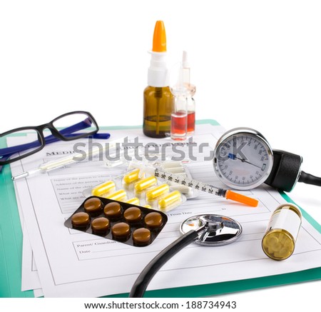 doctor\'s accessories, glasses and drugs on medical authorization form on green board on white background