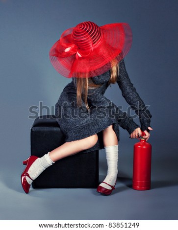fashion girl with fire extinguisher in big red hat and red shoes