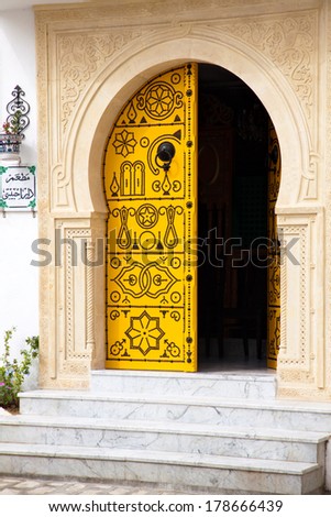 Traditional yellow door of Tunisia with black ornaments