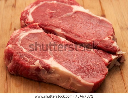 Raw Steak - raw rib eye steaks on the cutting board
