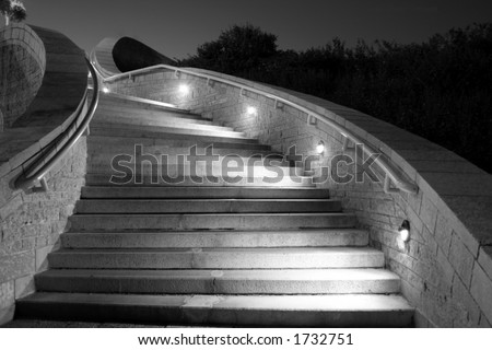 This picture is a night shot of concrete stairs while lights illuminate the direction to follow.