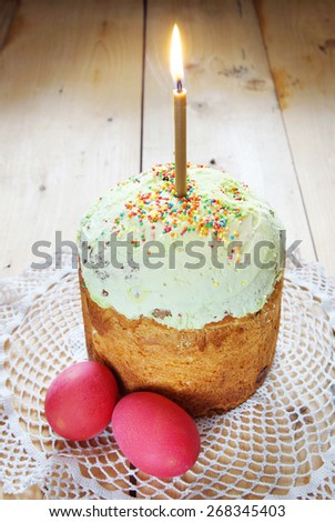 Classical Christian Easter still life with red eggs and burning candle over the cake
