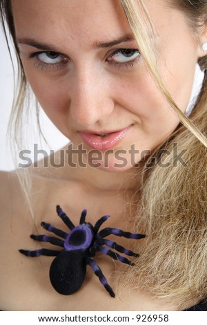 Portrait of a beautiful blond woman playing with a black spider