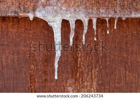 icicles hanging down on a wooden wall