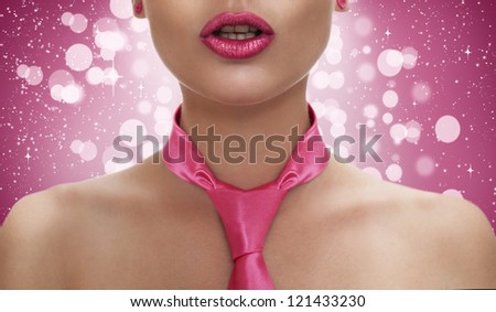 attractive young model with pink shiny lips wearing a pink tie on pink background with bokeh and sparkles