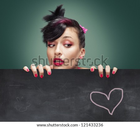 crazy teenager looking from above a blackboard on greenish background