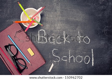 back to school concept with various staff on blackboard background