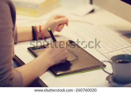 a graphic designer is working and using a graphic tablet