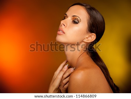 close-up studio portrait of young beautiful tanned woman with long acrylic leopard nails and makeup