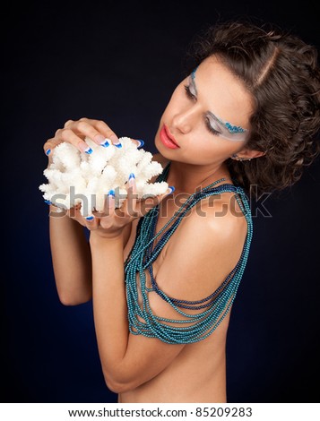 Portrait of beautiful woman with carly dark hair and shells in hands