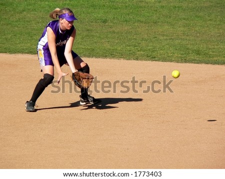 Girl Softball Player catching a bouncing Ball