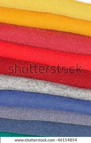 Stack of colored tee shirts on a shelf