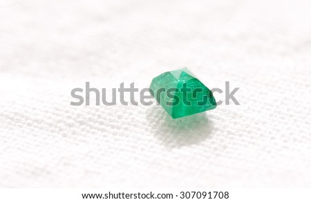 vibrant green beryl jewel cut crystal on a white background